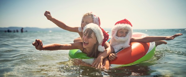 Kids floating on the ocean at Coogee Beach with Santa hats on